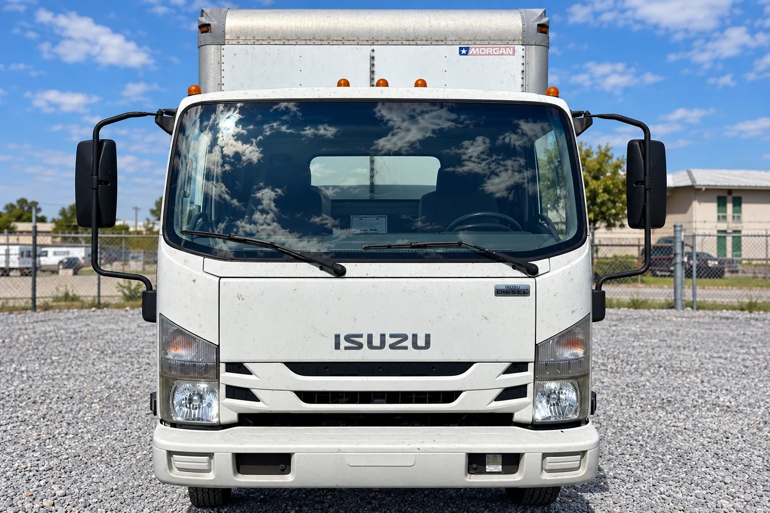 Front view of a white Isuzu box truck with installed windshield.